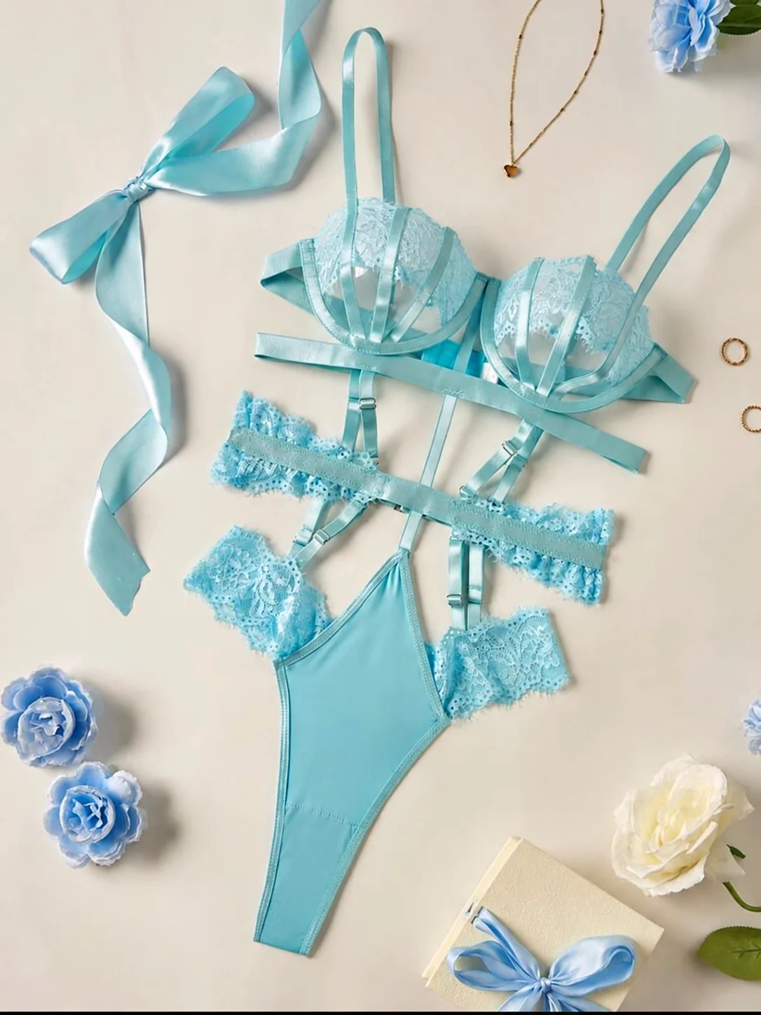 Conjunto de encaje azul cielo con lazos, fotografiado sobre una mesa